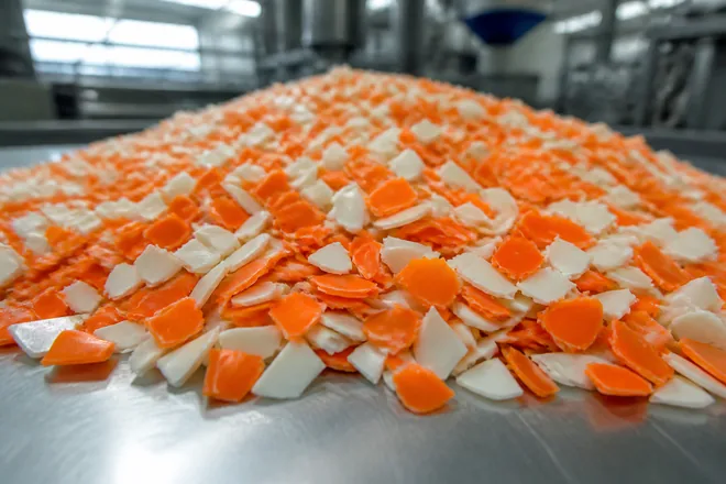 Clean orange and white plastic regrind flake from factory offcuts