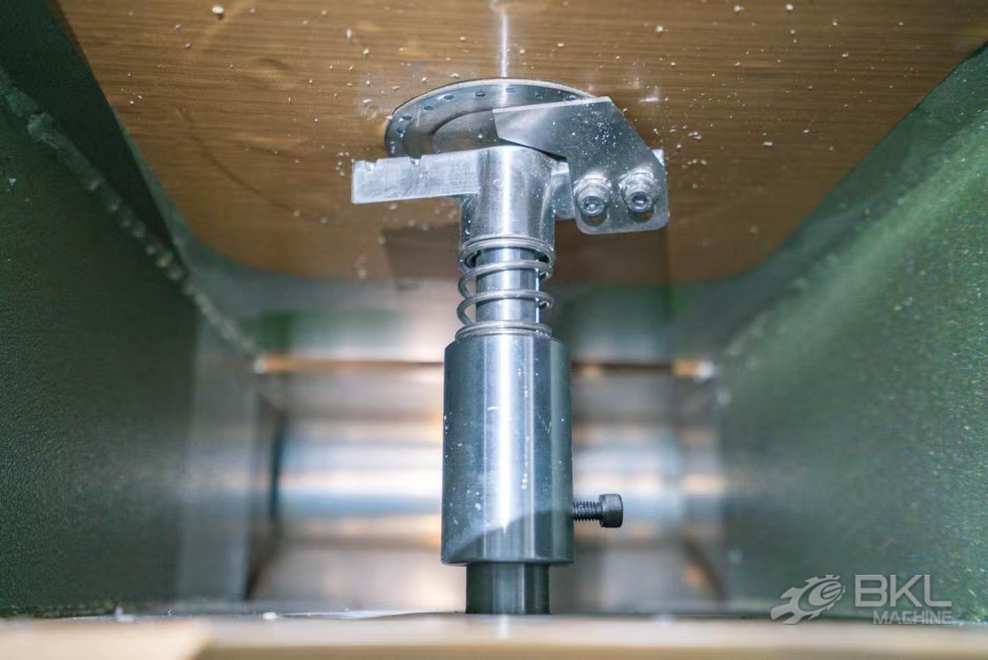 Spring-loaded die-face cutter head pressed against the perforated die plate inside the granulator chamber