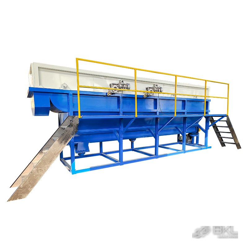 Sink-float washing tank from the walkway side with yellow safety railing, access stair and discharge chute
