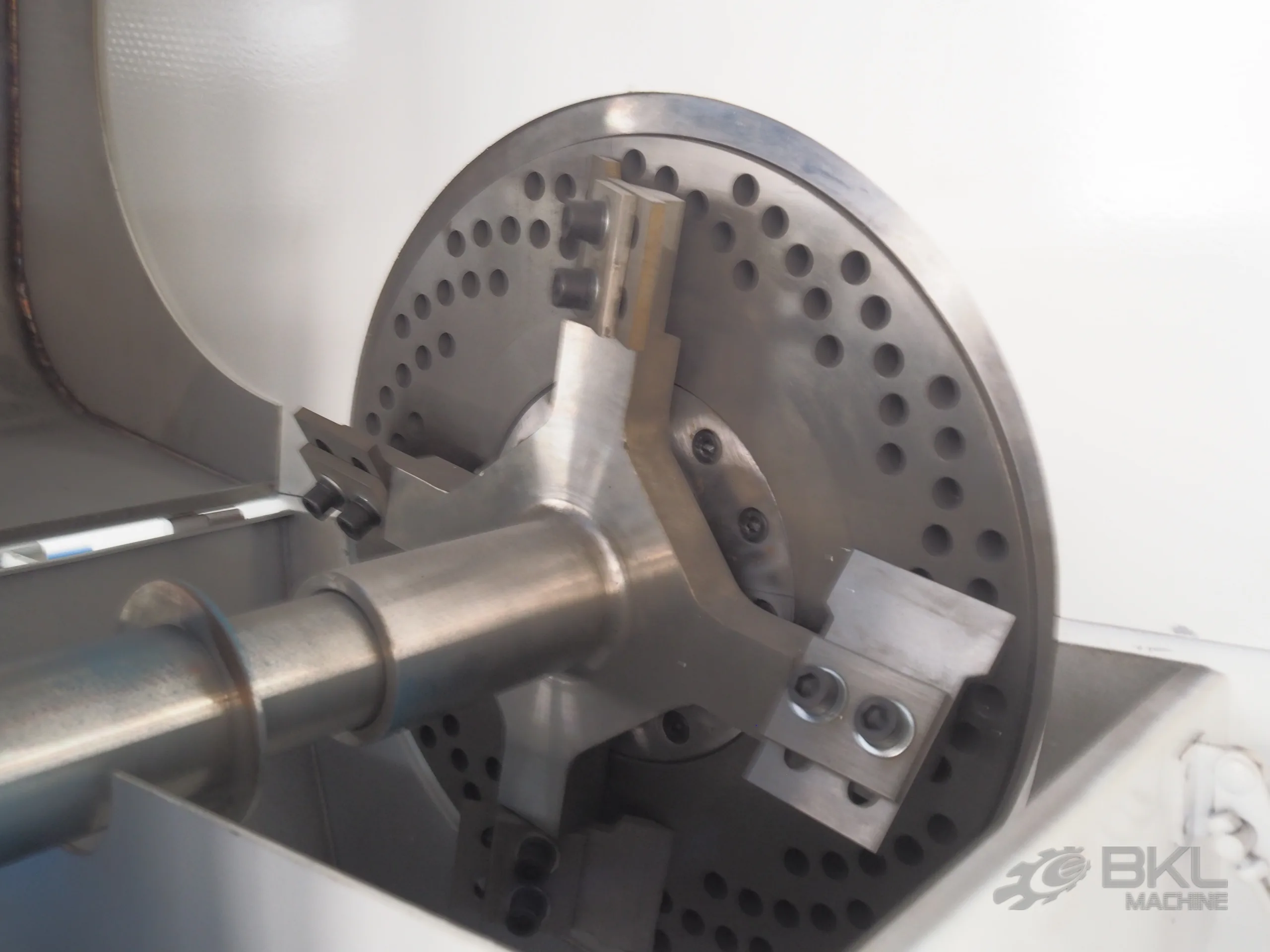 Perforated die plate with three-arm rotating cutter assembly and screw shaft at the squeezer discharge end