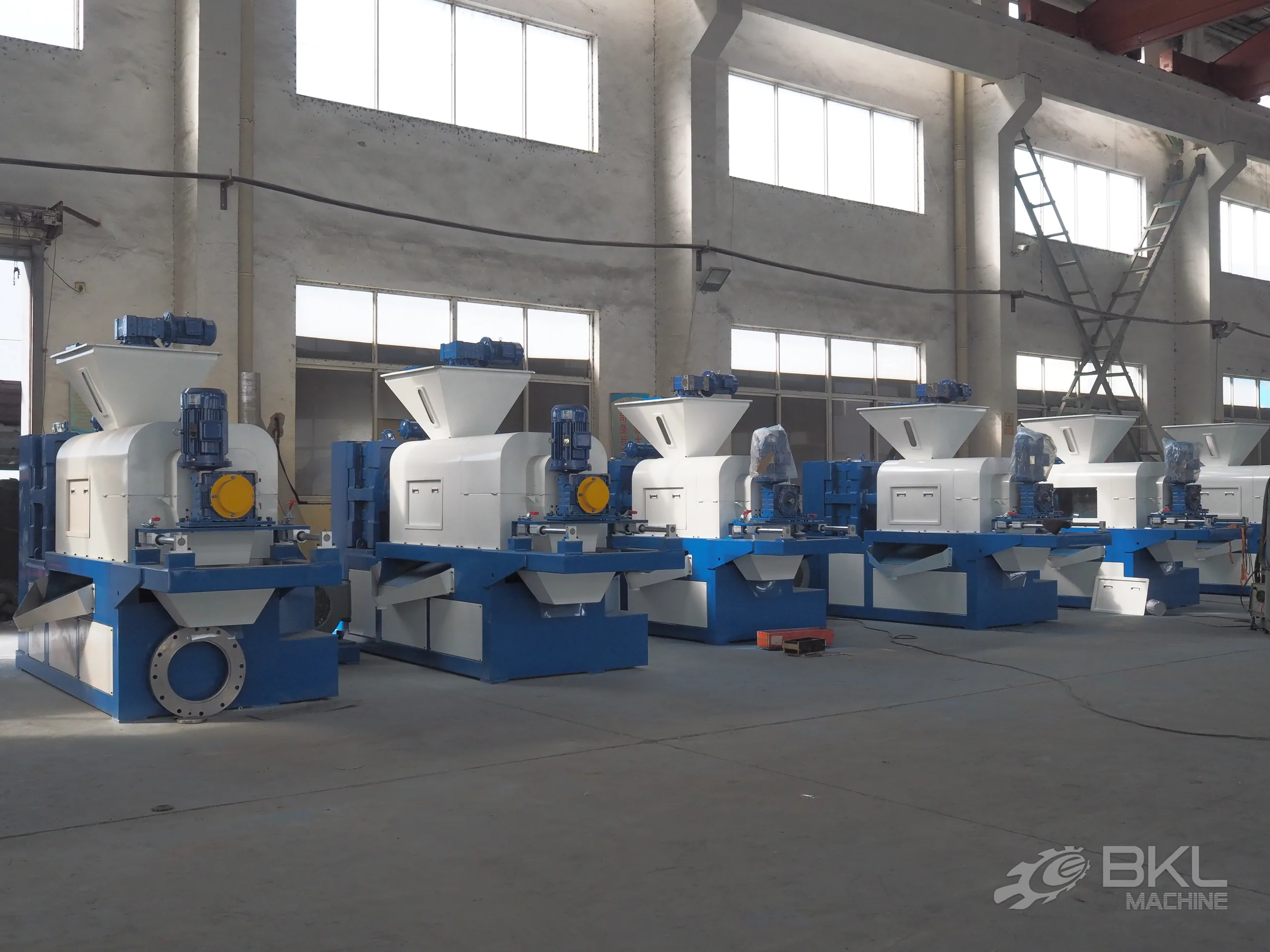 Row of six JG squeezer units lined up across the assembly workshop before shipment