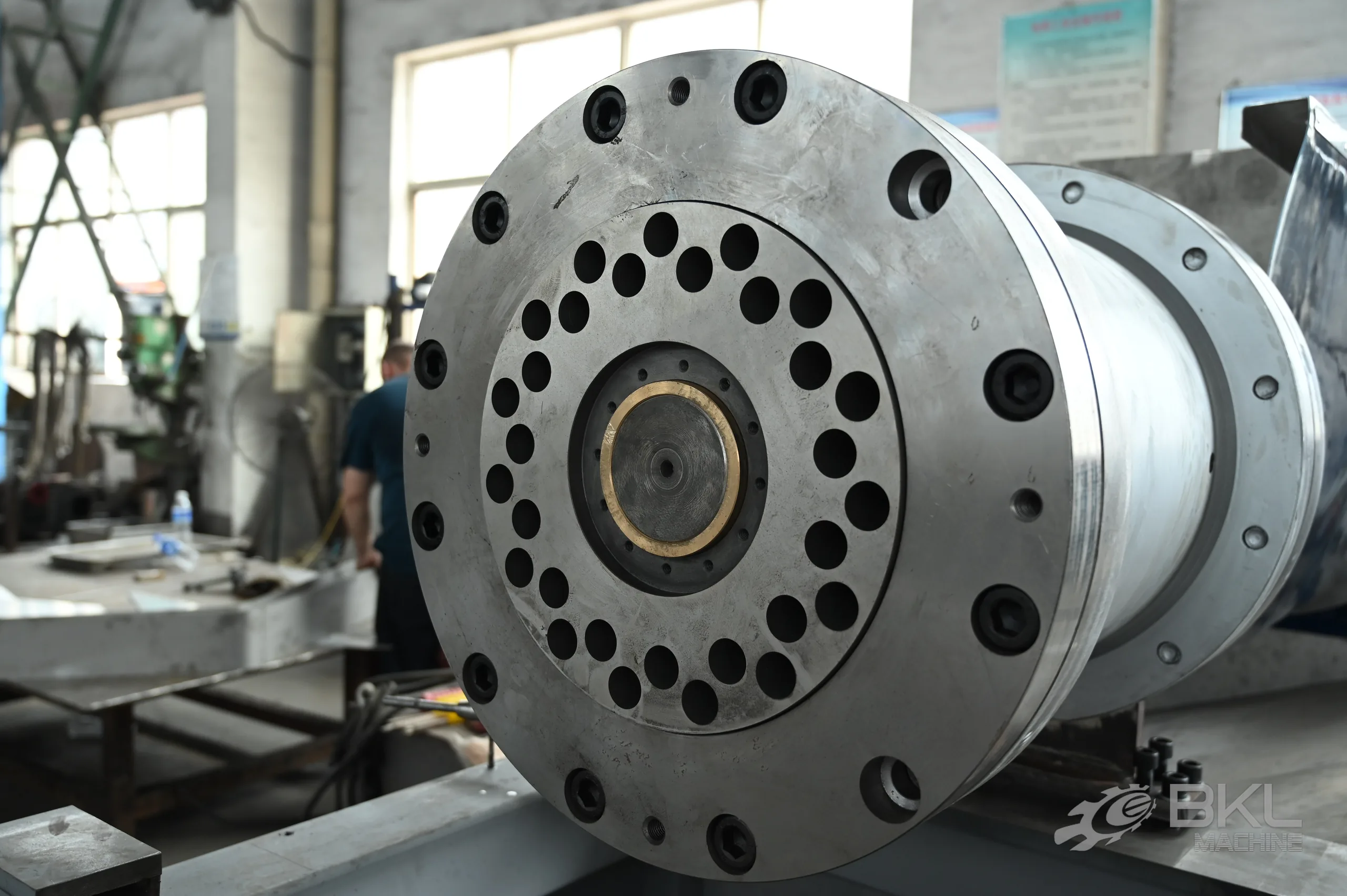 Bolted die head flange with a ring of pelletising holes and bronze centre bush on the barrel end