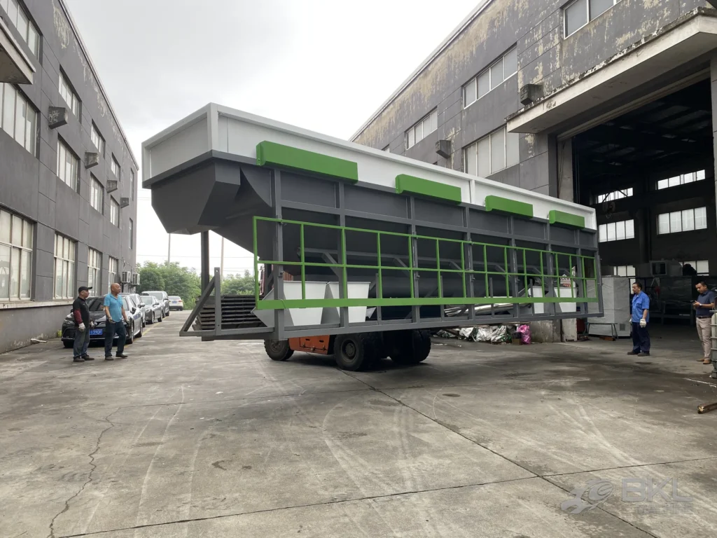 Oversized sink-float separation tank moved outdoors on a forklift, showing the full length of the unit