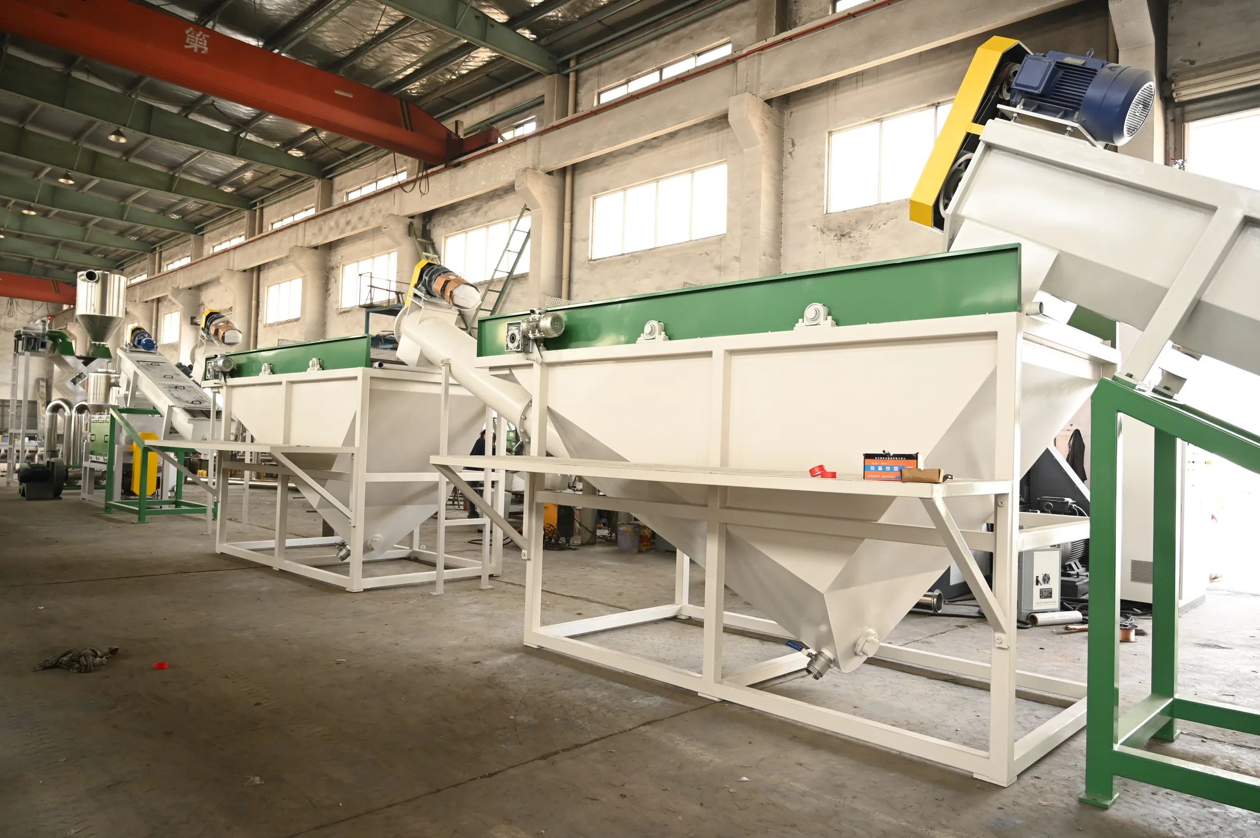 Two sink-float separation tanks in series with a screw lifter carrying floating flakes onward