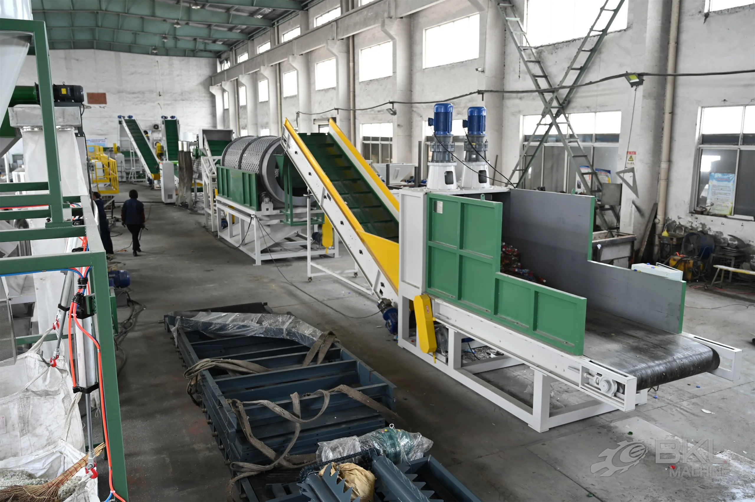 PET washing line under assembly with belt feeder, trommel drum and inclined conveyors in the workshop