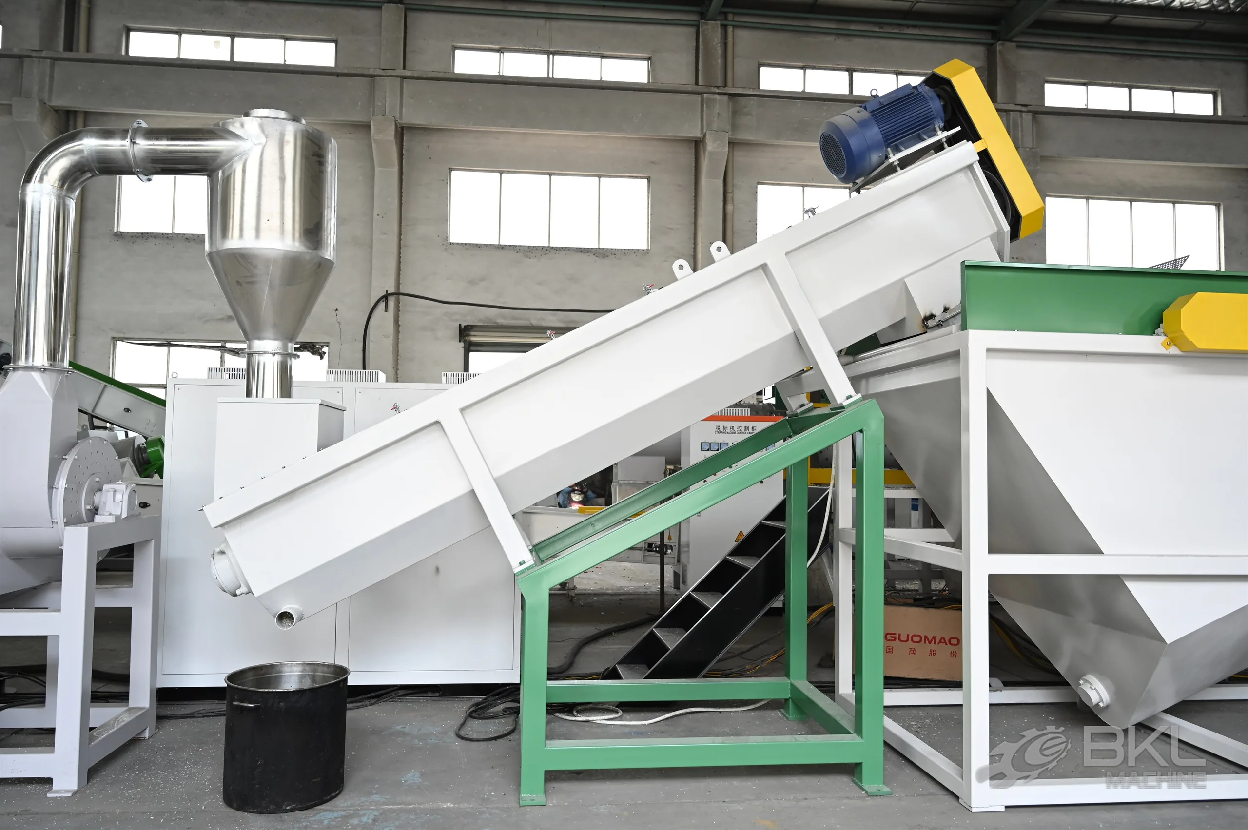 Inclined friction washer on a green support frame beside a cyclone and rinsing tank in a washing line