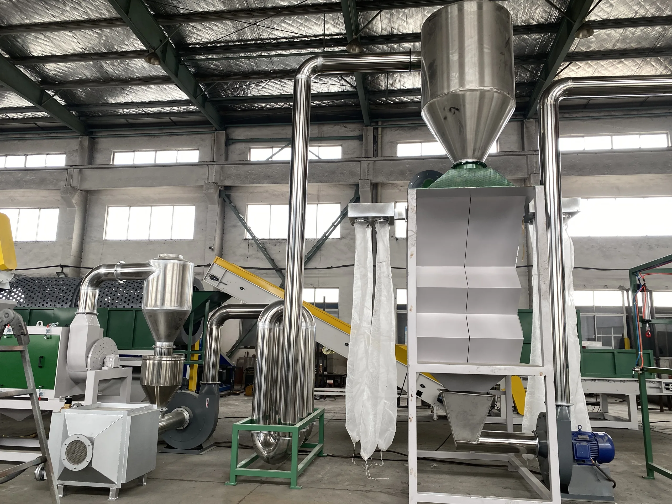 Pipe drying line with vertical stainless ducts, cyclones and a storage silo removing surface moisture