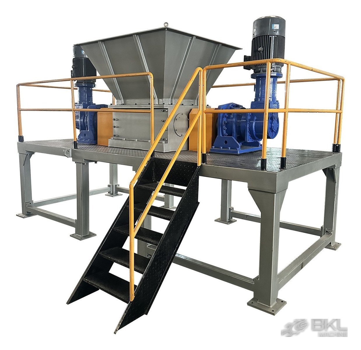 Twin-shaft shredder on a raised maintenance platform with yellow railings, access stair and two vertical motors