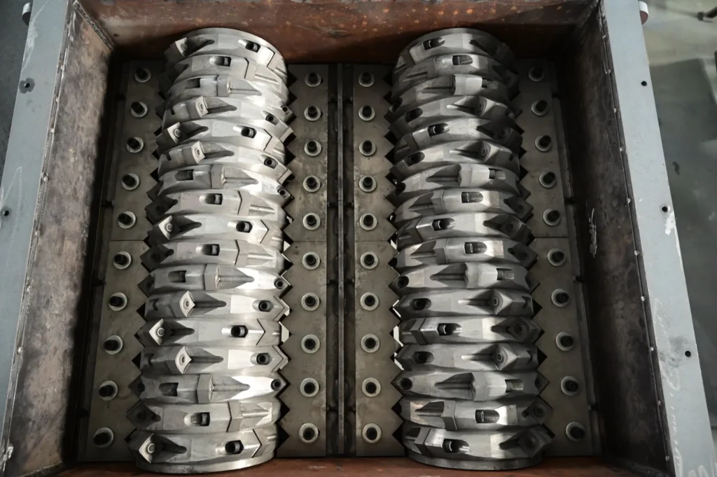 Close-up of twin shredder rotors fitted with carbide-tipped teeth, the tooling grade required for shredding steel-belted tyres
